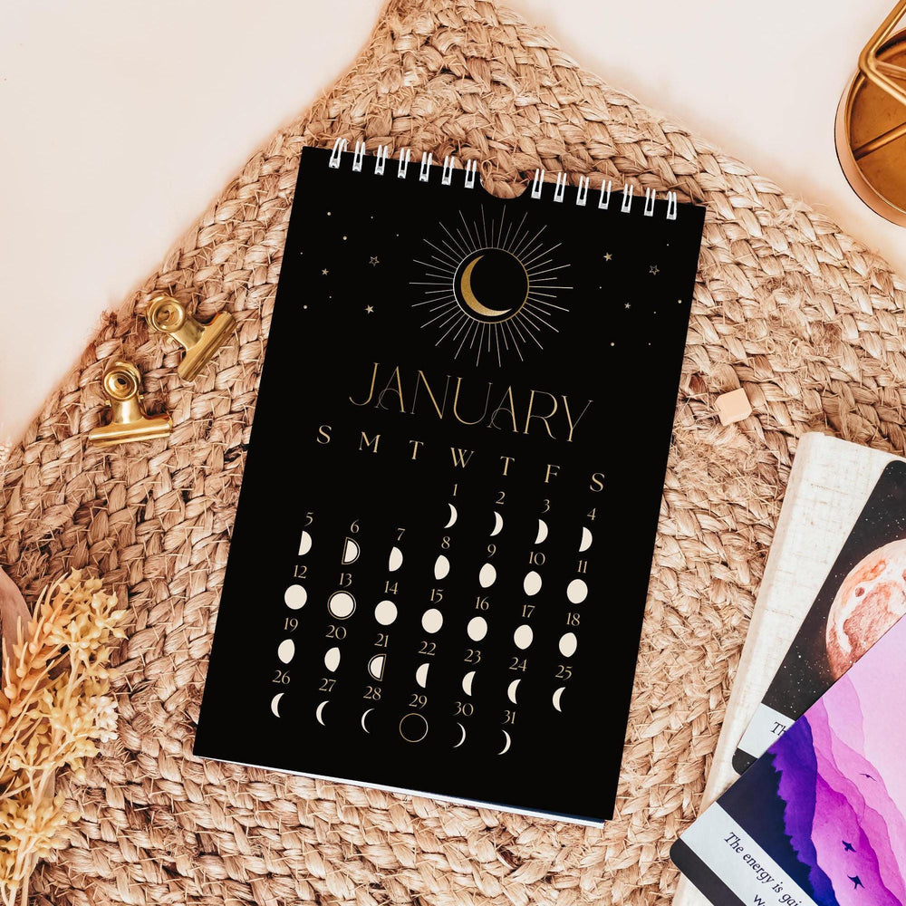 
                      
                        A monthly wall calendar that showcases the phase of the moon every day with a striking black white and faux gold design
                      
                    