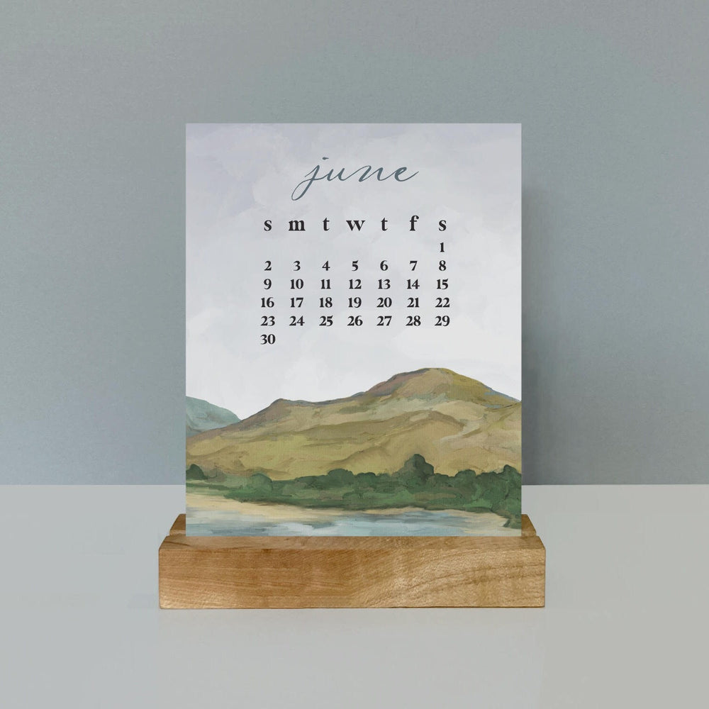 
                      
                        a hand illustrated landscape desk calendar with maple wood stand
                      
                    